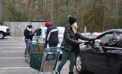 Interfaith of The Woodlands staff assist neighbors with food, grocery gift cards and gas cards at Drive Through Food Distribution this week.