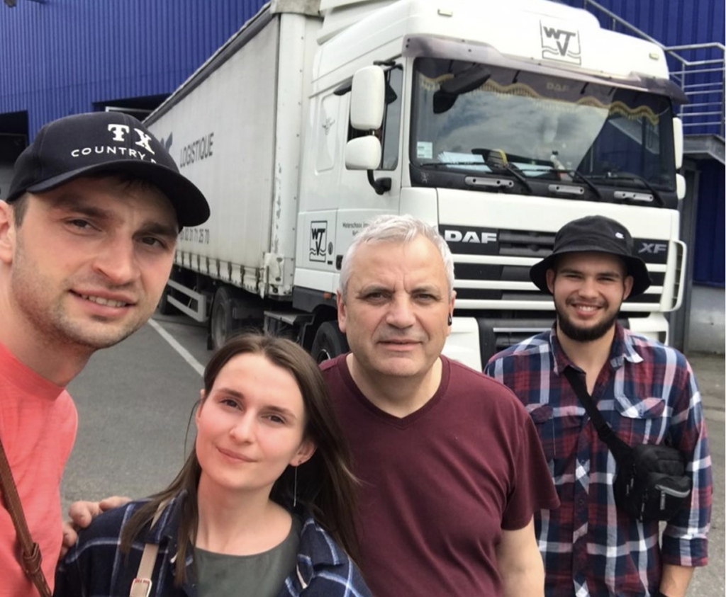 Pastor Marchuk, center, his son and daughter-in-law, left, and ministry partner, Vlad, right, with delivery truck