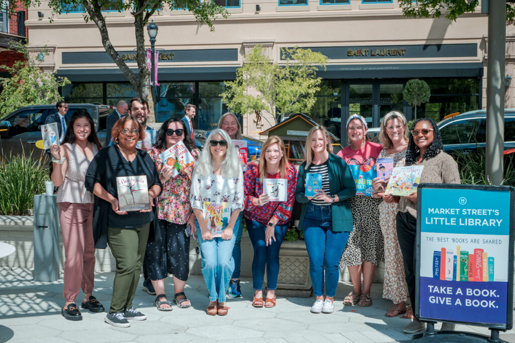 The Pavilion staff pose for a photo as they place a variety of arts-related books in the little free library at Market Street in celebration of the 101st birthday of its namesake, Cynthia Woods Mitchell.