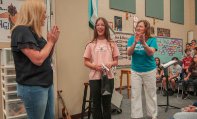 Julie Stobbe (right), Mitchell Intermediate School Choir Director, and Ashley Gravois (left), Marketing and Education Manager for The Pavilion, present an Arts in Action Award certificate and prize to nominated performing arts student, Anha Neal.