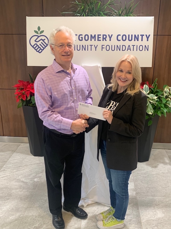 Photo Credit: Julie Martineau; (Left to right) Leland Dushkin, Board Member and Treasurer of Montgomery County Community Foundation, presents Teresa Kenney, founder, Reading Is Revolutionary, with a grant check to be used to expand literacy programs in Montgomery County, Texas