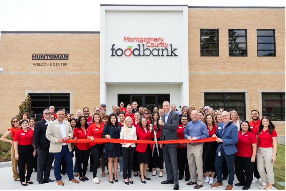 Kristine Marlow, President & CEO, cuts the ribbon of Montgomery County Food Bank’s “Build Today, Feed Tomorrow” facility expansion, alongside Chairman of the Board of Directors, Jim Carman (gray suit) and incoming President & CEO Scott Burns (blue suit).