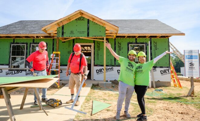 Future Habitat homeowners work alongside volunteers to build their home