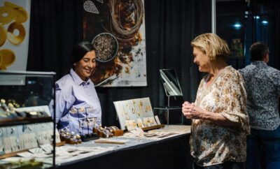 Jeweler Liliana Olmos visits with a customer during the 2025 Texas Fine Craft Show - VTW
